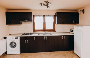 a kitchen with a sink and a washing machine at Casa Roland in Gheorgheni