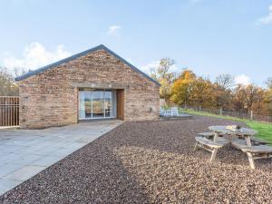 a brick building with a picnic table in front of it at Woodend Barn in Auchterarder