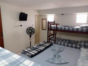 Cette chambre comprend 2 lits superposés et un ventilateur. dans l'établissement Pousada Videiras Santa Rita de Cássia, à Cachoeira Paulista