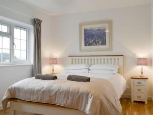 a bedroom with a large white bed with two lamps at The Orchard - UKC2496 in Newport