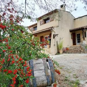 una casa con un árbol con flores rojas delante en Villa Les Chariotins, en Draguignan