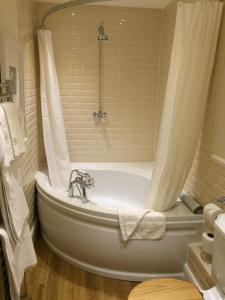 a bathroom with a bath tub with a shower at Trearddur Bay Hotel in Trearddur