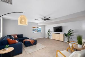 ein Wohnzimmer mit einem blauen Sofa und einem TV in der Unterkunft 4BR / Old Town Scottsdale / Shopping / Tempe in Scottsdale