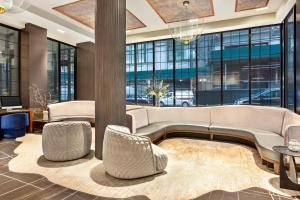a lobby with a couch and chairs and windows at Hyatt Centric Midtown 5th Avenue New York in New York