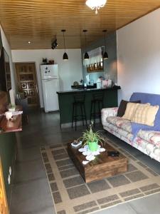 ein Wohnzimmer mit einem Sofa und einem Tisch in der Unterkunft Casa Aconchegante na Montanha in Campos do Jordão
