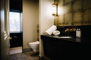 a bathroom with a black sink and a toilet at Arthurs in Hillsborough