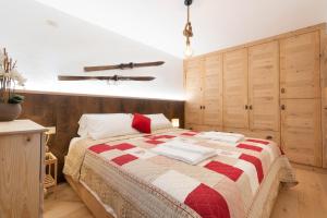 a bedroom with a bed with a red and white blanket at Ciasa de Chica in Pozza di Fassa +11 photos