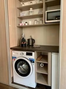 a kitchen with a washing machine and a microwave at Premium Casa Apartman in Sopron