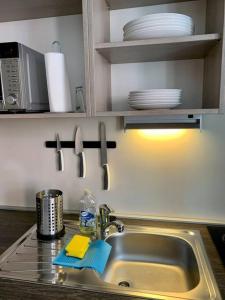 a kitchen counter with a sink and a microwave at Premium Casa Apartman in Sopron