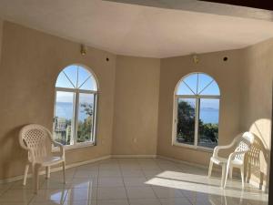 três cadeiras num quarto com três janelas em casa de campo em San Juan Tecomatlán