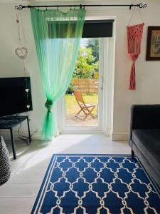 a living room with a blue rug and a sliding glass door at Lavender Den in London