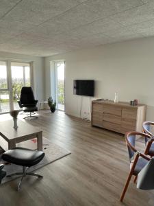 a living room with a flat screen tv and chairs at Nyt hus in Herning