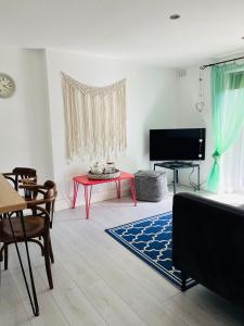 a living room with a red table and a television at Lavender Den in London