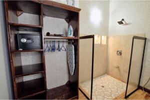 a bathroom with a shower with a microwave and a shower at Casita Don Eliber in Fortuna