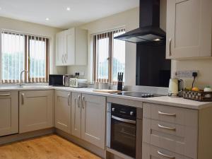 a kitchen with white cabinets and a stove top oven at Gardeners Lodge in Pembroke