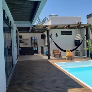 a patio with a hammock and a swimming pool at The Guest House pousada in Balneário Gaivotas