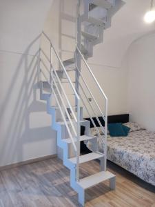 escalera blanca en una habitación con cama en La Casetta di Giulia, en Dolceacqua