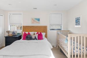 a bedroom with a crib with pink and white pillows at La Sirena in Montauk