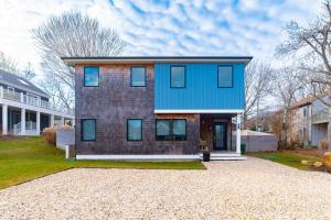 a house with a blue roof on a gravel driveway at La Sirena in Montauk