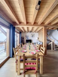 a dining room with a wooden table and chairs at Chalet Le Gebroulaz in La Toussuire