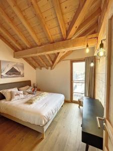 a bedroom with a large bed and a wooden ceiling at Chalet Le Gebroulaz in La Toussuire