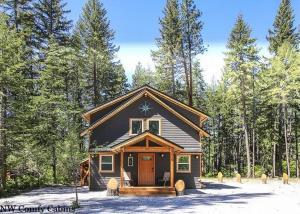 a small house in the middle of a forest at Compass Cabin by NW Comfy Cabins in Leavenworth