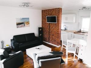 a living room with a black couch and a brick wall at Gemütliches Ferienhäuschen an der Schlei & Ostsee in Maasholm