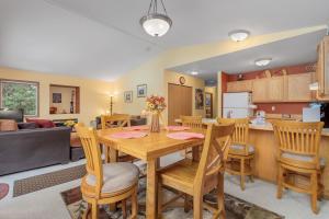 uma cozinha e sala de estar com uma mesa de madeira e cadeiras em Suite Serenity Condo by NW Comfy Cabins em Leavenworth