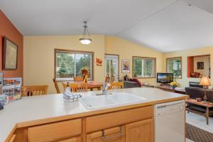 uma cozinha com um lavatório e uma sala de estar em Suite Serenity Condo by NW Comfy Cabins em Leavenworth
