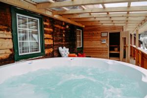 a bath tub in a room with a window at Rösslgut Bed & Breakfast in Zederhaus