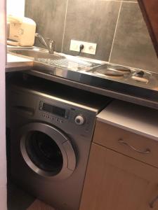 een keuken met een wastafel en een wasmachine bij Studio indépendant avec terrasse-climatisation in Marseille