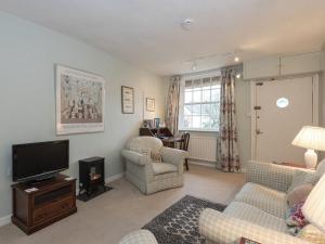 a living room with a tv and chairs and a table at Little Trout in Middle Wallop