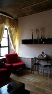 een woonkamer met een rode bank en een tafel bij Lister Mills, Apartment 327, Silk Warehouse, Lilycroft Rd, BD9 5BD in Bradford
