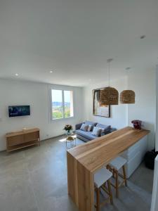 uma cozinha e sala de estar com uma grande mesa de madeira em Belle vue sur mer, très près du port de Sanary em Sanary-sur-Mer