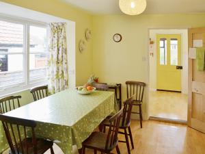 a dining room with a green table and chairs at The Castaway in Mundesley