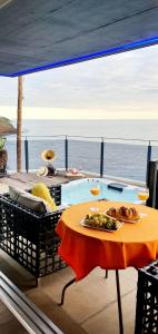 uma mesa com um prato de comida ao lado de uma piscina em Casa da Rocha em Paul do Mar