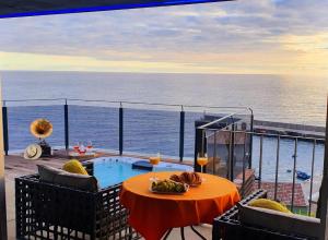 a balcony with a table with a bowl of food at Casa da Rocha in Paul do Mar