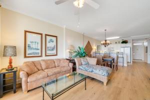 uma sala de estar com um sofá e uma mesa em Regency Isle 802 em Orange Beach