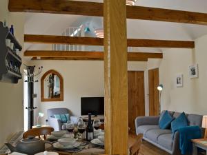 a living room with a table and a couch at Cornbrash Farm Cottage in Dallington