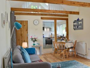 a living room with a couch and a table at Cornbrash Farm Cottage in Dallington