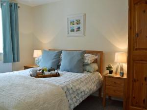 a bedroom with a bed with a tray on it at Cornbrash Farm Cottage in Dallington