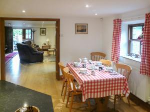 ein Wohnzimmer mit einem Tisch mit einem roten und weißen Tischtuch in der Unterkunft Hollin Bank Cottage in Salterforth