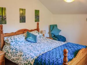 a bedroom with a bed with a blue comforter at Hollin Bank Cottage in Salterforth