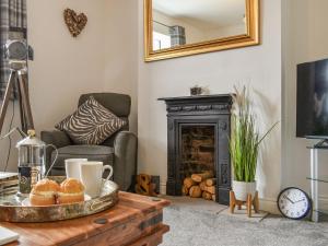 a living room with a coffee table with a fireplace at Mills Croft in Hognaston