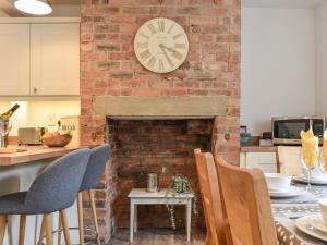 Hognaston的住宿－Mills Croft，厨房设有砖砌壁炉,墙上挂着时钟