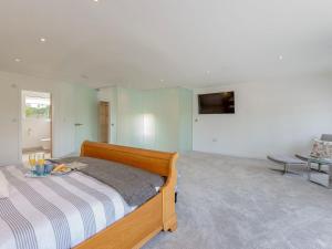 a bedroom with a bed with a table and a television at Rosedene in Freshwater