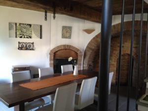a dining room with a table and a fireplace at Altes Backhaus in Maranzana in Mombaruzzo