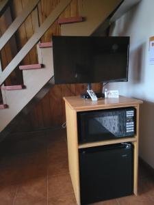 Ein TV auf einem Stand mit einem Fernseher oben in der Unterkunft The Ranch Motel in Oakland