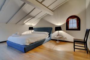 1 dormitorio con 1 cama azul y 1 silla en Villa Oasis by SanSe Holidays, en San Sebastián