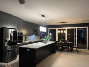 a kitchen with a black refrigerator and a table with chairs at Sea Winds Bungalow - Tierra Del Sol Aruba in Noord